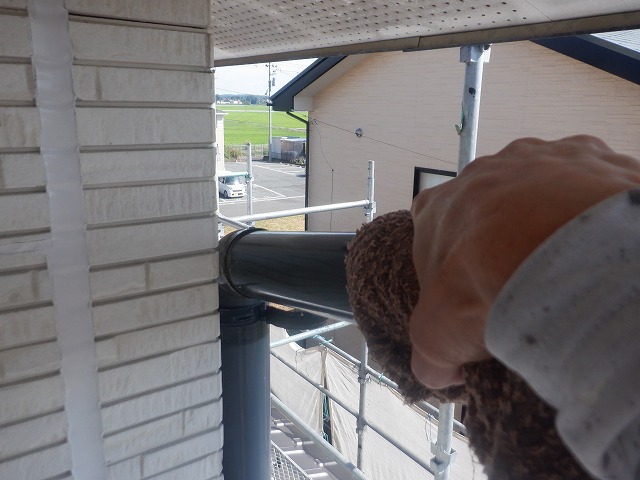 ウエスで雨樋の汚れを水拭きしている様子