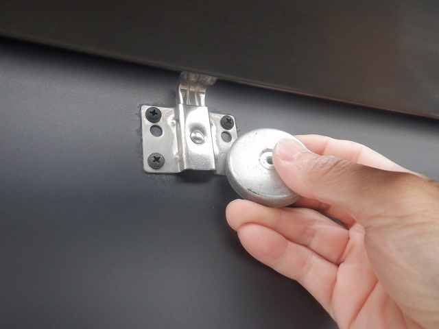 吊り金具に磁石を当てて反応を確認している様子