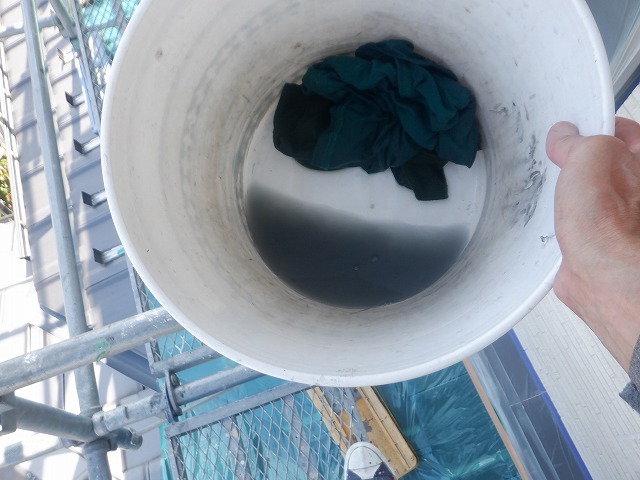 鼻隠し板を水拭きした後の汚れたウエスと水