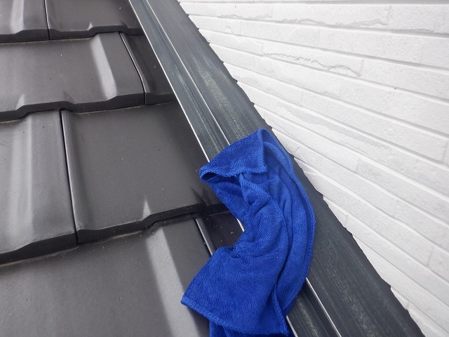 雨押え板金を水拭きしている様子